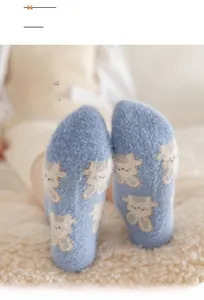 Dettaglio calzini in pile blu con motivo a coniglio su un morbido tappeto di peluche