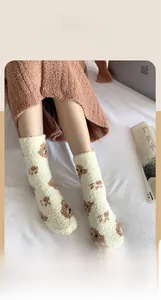 Close-up of warm coral fleece mid-calf socks with cute brown bear cartoon patterns