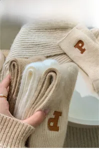 Close-up of thick knitted wool socks with P letter embroidery and fuzzy texture