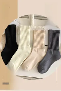 Dettaglio di calze spesse in cotone a coste nere, bianche, beige e grigio scuro