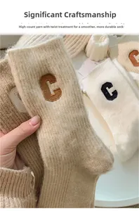 Detailed close-up of wool socks with embroidered C letter showing high-twist yarn texture