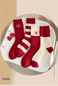 Detailed texture of red and beige wool socks with festive cat embroidery patterns