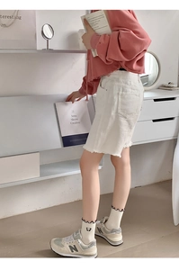 Pink cropped hoodie and white denim shorts styled with frilled socks for a cozy look