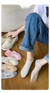 Close-up of low-cut cotton invisible socks with cute smile embroidery in neutral tones