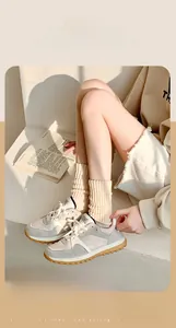 Dettaglio trama a maglia di calze calde beige abbinate a scarpe da ginnastica grigie