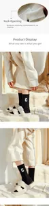 Detail of embroidered white C letter on thick black wool socks with soft knit texture