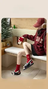 Close-up of thick red cashmere socks with white embroidery in a cozy festive setting