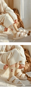 Close-up of beige wool socks with embroidered C letter and thick knit texture