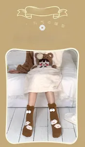 Detail of coral fleece brown bear socks with cute paw patterns and plush embroidery fabric