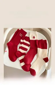 Close-up of red cashmere knit socks set featuring cat embroidery and striped patterns