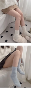 Detail of warm cable knit winter socks in white and light blue wool blend fabric