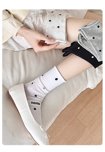 Detail of polka dot mesh socks in white, gray, and black colors for a breathable summer style