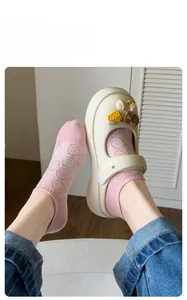 Detail of pink pure cotton ankle socks with smile pattern and beige garden clogs