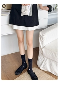 Detailed texture of knitted mid-calf socks with classic polka dots and mesh pattern