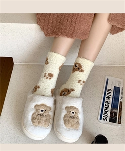 Detail of warm white coral fleece socks featuring cute brown teddy bear embroidery patterns