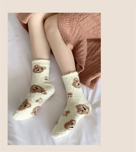 Detail of coral fleece winter socks with cute cartoon bear pattern and soft plush texture