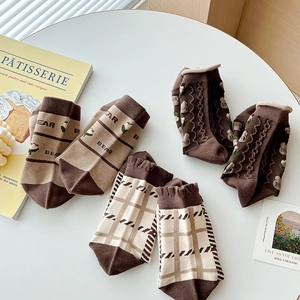 Chaussettes vintage en coton marron avec rayures et motif ours sur table blanche