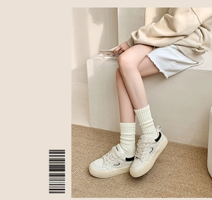 Dettaglio di calze termiche bianche in cotone a coste abbinate a scarpe da ginnastica