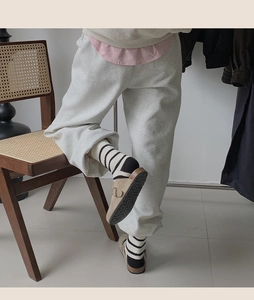 Close-up of vintage striped crew socks worn with suede clogs on a wooden chair