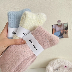 Three pairs of plush winter crew socks in pastel blue, beige, and pink with colorful speckles