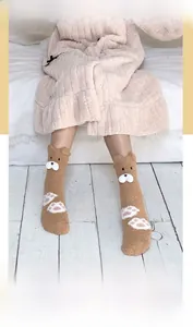 Detail of coral fleece socks featuring 3D cartoon bear ears and cute paw patterns