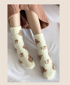 Detail of soft cream coral fleece warm socks with brown bear pattern for winter