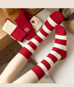 Close-up of red and white striped cashmere socks with embroidered 'Keep your head up' text