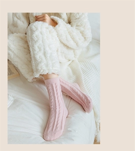 Close-up of pink coral fleece socks featuring a warm thick cable knit texture