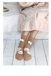 Close-up of fluffy coral fleece socks with 3D cartoon bear ears and white paw prints