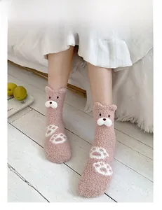 Detail of pink coral fleece sock with 3D bear face and paw print pattern on floor