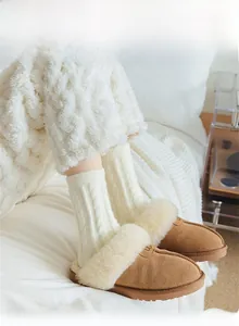 Detail of cozy brown suede boots with white faux fur lining and cable knit socks