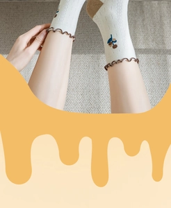 Close-up of cotton crew socks with brown ruffle edge and small fruit embroidery