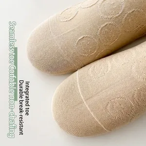 Beige cotton no-show socks featuring seamless toe design and knitted smile face pattern