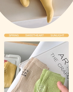 Detail of colorful ribbed cotton socks with minimalist side embroidery in spring colors