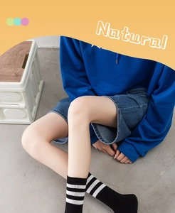 Close-up of black cotton mid-calf socks with white stripes in a casual street setting