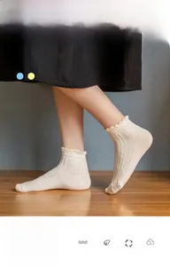 Close-up of white cotton ankle socks featuring scalloped lace cuffs and ribbed texture