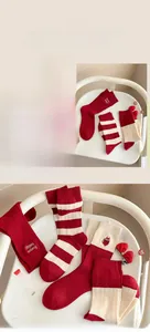 Close-up of red and white striped cashmere socks with cute kitten embroidery details
