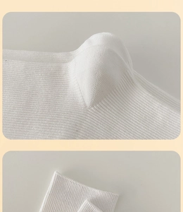 Detail of white ribbed cotton mid-calf socks with reinforced heel and tight cuff weaving