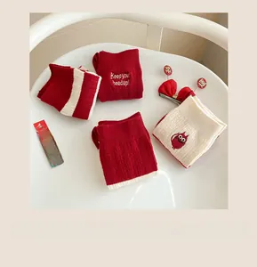 Detailed knit of red and cream cashmere socks featuring festive embroidery and stripes