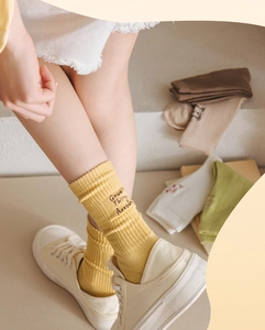 Detailed knit texture of ribbed cotton socks featuring 'Good Things Around' embroidery