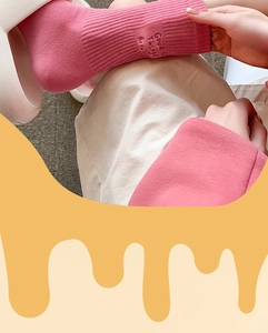 Detail of pink cotton ribbed socks with white embroidery paired with white slippers