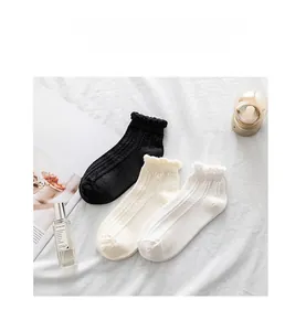 Detail of three pairs of cotton socks featuring elastic ruffle cuffs and vertical knit texture