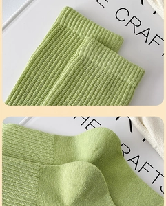 Detailed macro view of light green ribbed cotton socks showing the elastic cuff and heel texture