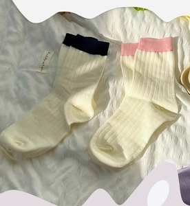 Detail of ribbed cotton mid-calf socks with contrast trim in navy and pink colors