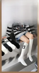 Gros plan de chaussettes montantes en coton à rayures noires et blanches avec lettre B