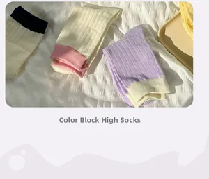 Detailed view of color-block knee-high ribbed knit socks in black, pink and purple