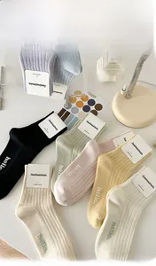 Detail of ribbed combed cotton socks in multiple pastel colors with branding cards