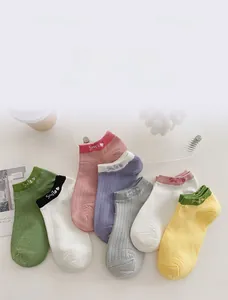 Detailed view of colorful low cut cotton socks with Smile embroidery and ribbed texture