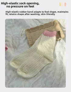 Close-up of beige knit crew socks featuring pink ribbed cuffs and vertical stripe texture
