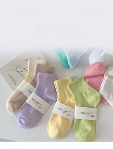 Flat lay of colorful ribbed cotton socks in pastel macaron shades with branded packaging
